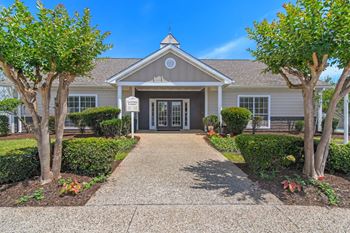 The front of a house with a walkway and trees